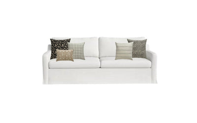 A composite photo of a white sofa with 5 pillows. 3 pillows on left side of sofa, two on the right. 2 large pillows, two smaller pillows, and a lumbar pillow. 